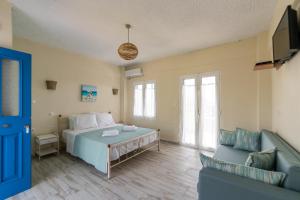 een slaapkamer met een groot bed en een bank bij Cyclades Luxury Studios in Nea Potidaea