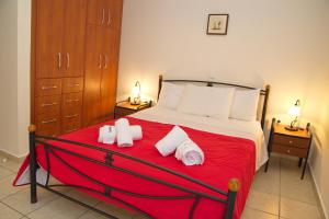 a bedroom with a bed with red sheets and towels at To Pithari in Skiros