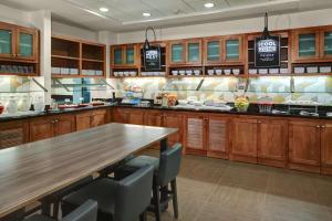 a large kitchen with a wooden table and chairs at Hyatt Place Memphis Primacy Parkway in Memphis