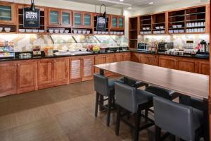 a kitchen with a table and chairs in a restaurant at Hyatt Place Memphis Primacy Parkway in Memphis
