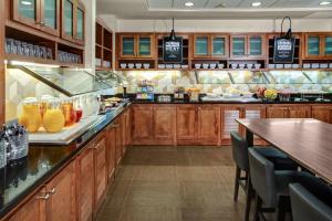 a large kitchen with wooden cabinets and a bar at Hyatt Place Memphis Primacy Parkway in Memphis