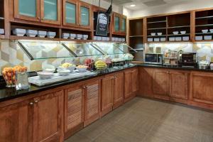 a kitchen with wooden cabinets and plates of food at Hyatt Place Memphis Primacy Parkway in Memphis