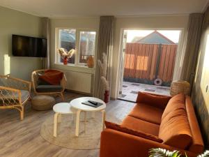 una sala de estar con un sofá y una mesa en Charley's Home 4 personen, en Westkapelle