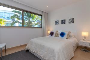 a white bedroom with a bed and a large window at Vila Castelo Parque in Ferragudo +145 photos