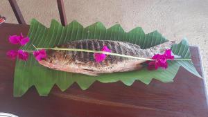 un poisson sur une feuille de bananes avec des fleurs sur celle-ci dans l'établissement African Ecolodge Angurman, à Bruce