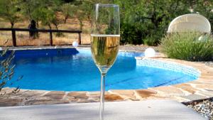 a glass of champagne sitting on a table near a pool at Cortijo Don Camilo de La HUMA in El Chorro