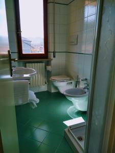 La salle de bains est pourvue de 2 lavabos et de 2 toilettes. dans l'établissement Hotel Ristorante Da Roverino, à Comunanza