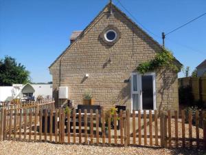 レイコックにあるBeautiful 2 bedroom guest house with private pool in Lacock, Wiltshireの木塀のある小さなレンガ造りの建物