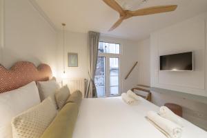 a bedroom with a large white bed with a tv at Le Leopold in Antwerp