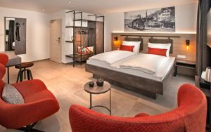 um quarto com uma cama e 2 cadeiras vermelhas em Rose Bistro & Gästezimmer em Altensteig