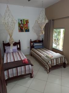 a bedroom with two beds and a window at CASA DA MATA descanso e sossego na natureza in Ibicoara