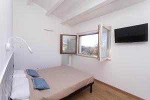 um quarto com uma cama e uma televisão de ecrã plano em A06 - Massignano, meravigliosa camera con vista em Massignano