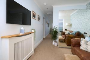 a living room with a couch and a tv on a wall at Channel View Boutique Hotel - Adults Only in Paignton
