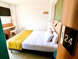 Una habitación de hotel con una cama en una habitación en The Originals City, Hôtel Le Puech, Narbonne, en Narbona