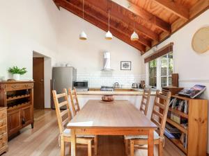 a kitchen with a wooden table and chairs at Mountain Den in Blackheath