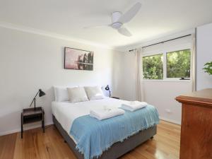 a bedroom with a bed with white sheets and a window at Mountain Den in Blackheath