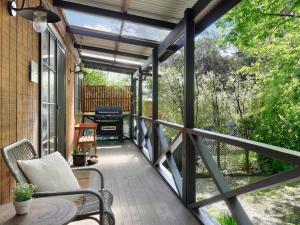 a screened in porch with a bench and a table at Mountain Den in Blackheath