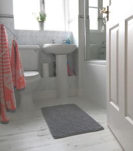 Baño blanco con lavabo y aseo en Lanhydrock View en Bodmin