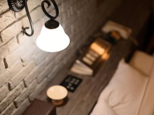a light hanging from a wall next to a bed at Fun3 -Adult Only- in Yokohama