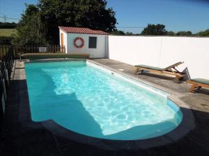 a large swimming pool with blue water in a backyard at Beautiful 2 bedroom guest house with private pool in Lacock, Wiltshire in Lacock