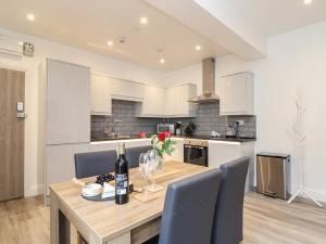 a kitchen and dining room with a wooden table and chairs at West Chambers in Camborne