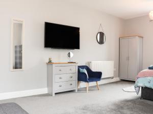 a bedroom with a tv on the wall and a chair at West Chambers in Camborne