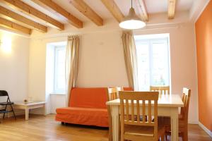 uma sala de estar com uma mesa de jantar e um sofá em Trentino Apartments - Il Gufo Vacanze em Borgo