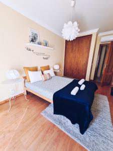 a bedroom with a large bed with a blue blanket at DOWNTOWN-Guest House in Olhão