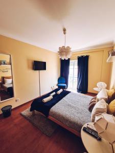 a bedroom with a large bed and a couch at DOWNTOWN-Guest House in Olhão