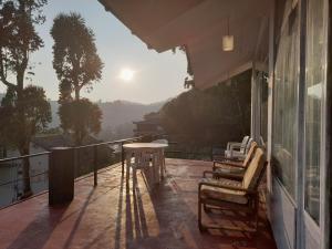 un balcone di una casa con tavolo e sedie di woods hut a Nuwara Eliya