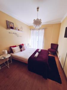 a bedroom with a large bed and a chair at DOWNTOWN-Guest House in Olhão