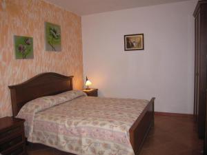 um quarto com uma cama e duas fotografias na parede em Agriturismo La Casa Vecchia em Ascea