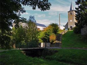 un pont sur une rivière en face d'une église dans l'établissement "A la douane", à Hestrud