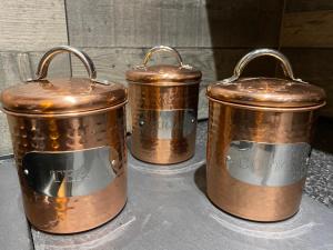 three copper canisters sitting on a table at Taigh Neonach in Watten