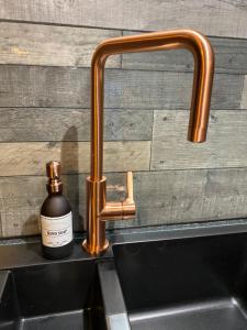 a bottle of soap sitting next to a faucet on a sink at Taigh Neonach in Watten