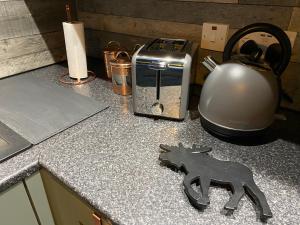 a counter top with a tea kettle and a horse holder at Taigh Neonach in Watten