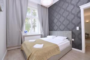 een slaapkamer met een bed met twee handdoeken erop bij Victus Apartamenty, Apartamenty Manhattan in Sopot