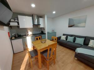 a kitchen and a living room with a table and a couch at Muralha Azibo Dreams in Santa Combinha