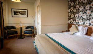 a hotel room with a bed and a table and chairs at The White House in Kinsale