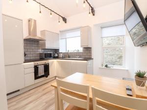 a kitchen with a wooden table and a dining room at Battell Chambers in Camborne