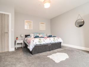 a white bedroom with a bed and a white rug at Battell Chambers in Camborne