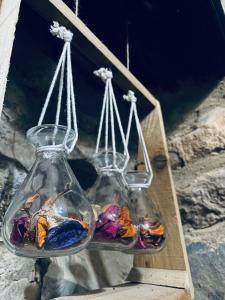 two glass vases filled with rocks in a wooden box at ROSES HOUSE OMAN in Jabal Al Akhdar