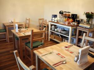 a dining room with wooden tables and chairs at Edinburgh Holiday Guest House in Edinburgh