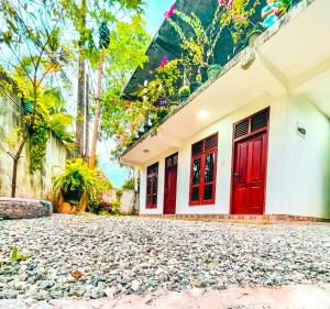 una casa con porte rosse e un vialetto di ghiaia di Coco Mount Mirissa a Matara