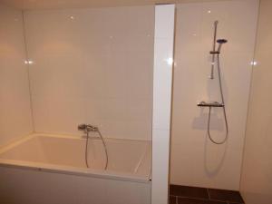 a bathroom with a bath tub with a shower at Bed & Coffee Maricoweg in Den Burg