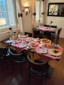 Lucia's Gästehaus "Zur Mühle" في Büchen: طاولة طعام مع أطباق من الطعام عليها