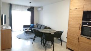 een woonkamer met een tafel en stoelen en een bank bij Apartamenty Color - Niebieski in Kielce
