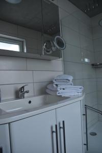 a white bathroom with a sink and a mirror at Ferienwohnung Steigerwaldblick in Dingolshausen