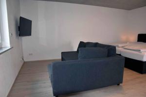 a living room with a couch and a bed at Ferienwohnung Steigerwaldblick in Dingolshausen +19 photos