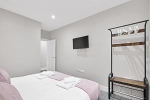 1 dormitorio con 1 cama y TV en la pared en Crown Place 2 & 3 Bedroom Luxury Apts with Parking in Shepperton By 360Stays en Shepperton